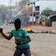 A supporter of Kenyan opposition leader Raila Odinga throws stones during a protest in Kisumu.